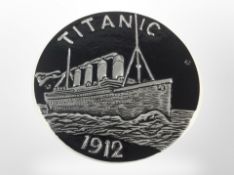A cast-aluminium Titanic plaque, diameter 24cm.