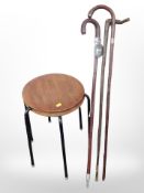Two 20th century laminated teak and metal footstools plus three walking sticks