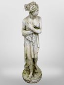 A concrete garden statue of a scantily-draped lady, height 122cm.