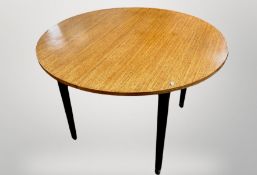 A 20th century oak circular dining table on tapered ebonised legs,