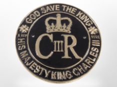 A cast-iron Charles III plaque, diameter 23cm.