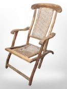 A teak and bergere folding steamer chair
