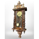 A 19th century Vienna eight day wall clock, with pendulum and key, height 104cm.