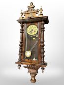 A 19th century Vienna eight day wall clock, with pendulum and key, height 104cm.