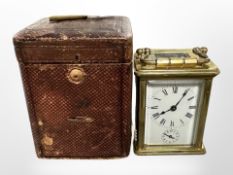 A miniature brass carriage clock, height 11cm including handle, in original leather travel case.