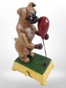 A novelty cast-iron Boxer dog with punch bag, height 18cm.