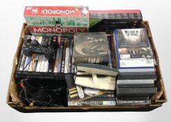 A box containing PlayStation 2 console, PS1 and PS2 games, DVDs, tablet in box, Monopoly game,