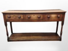 A George III oak dresser base, fitted with three drawers,
