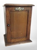 A Victorian oak smoker's cabinet and contents to include several pipes, etc, height 28cm.