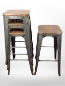 A set of four industrial-style metal and pine stacking stools.