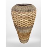 A large terracotta floor-standing vase bound in wicker, height 80cm (as found).