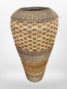 A large terracotta floor-standing vase bound in wicker, height 80cm (as found).