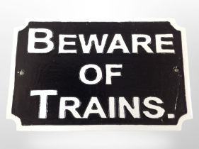 A cast-iron 'Beware of trains' plaque, width 30cm.