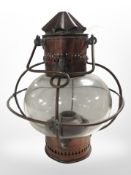 A 19th-century copper and glass oil lamp with swing handle, height 37cm.