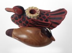 An Argentinian carved wooden figure of a duck, length 20cm, and a further candle-holding example.