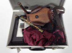 A set of Northumbrian pipes with bellows and a binder containing sheet music.