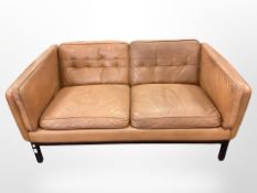 A late 20th century tan leather two seater settee,