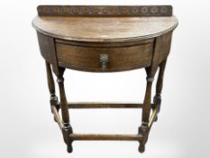 An early 20th century carved oak deni-lune hall table,