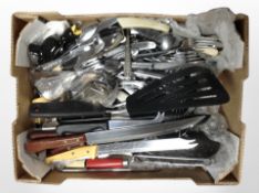 A box of assorted kitchen cutlery and utensils.