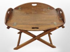 An oak butler's tray table on folding X-frame stand,