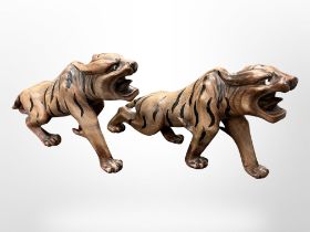 A pair of early 20th century Japanese carved and painted hardwood figures of tigers, length 30cm.