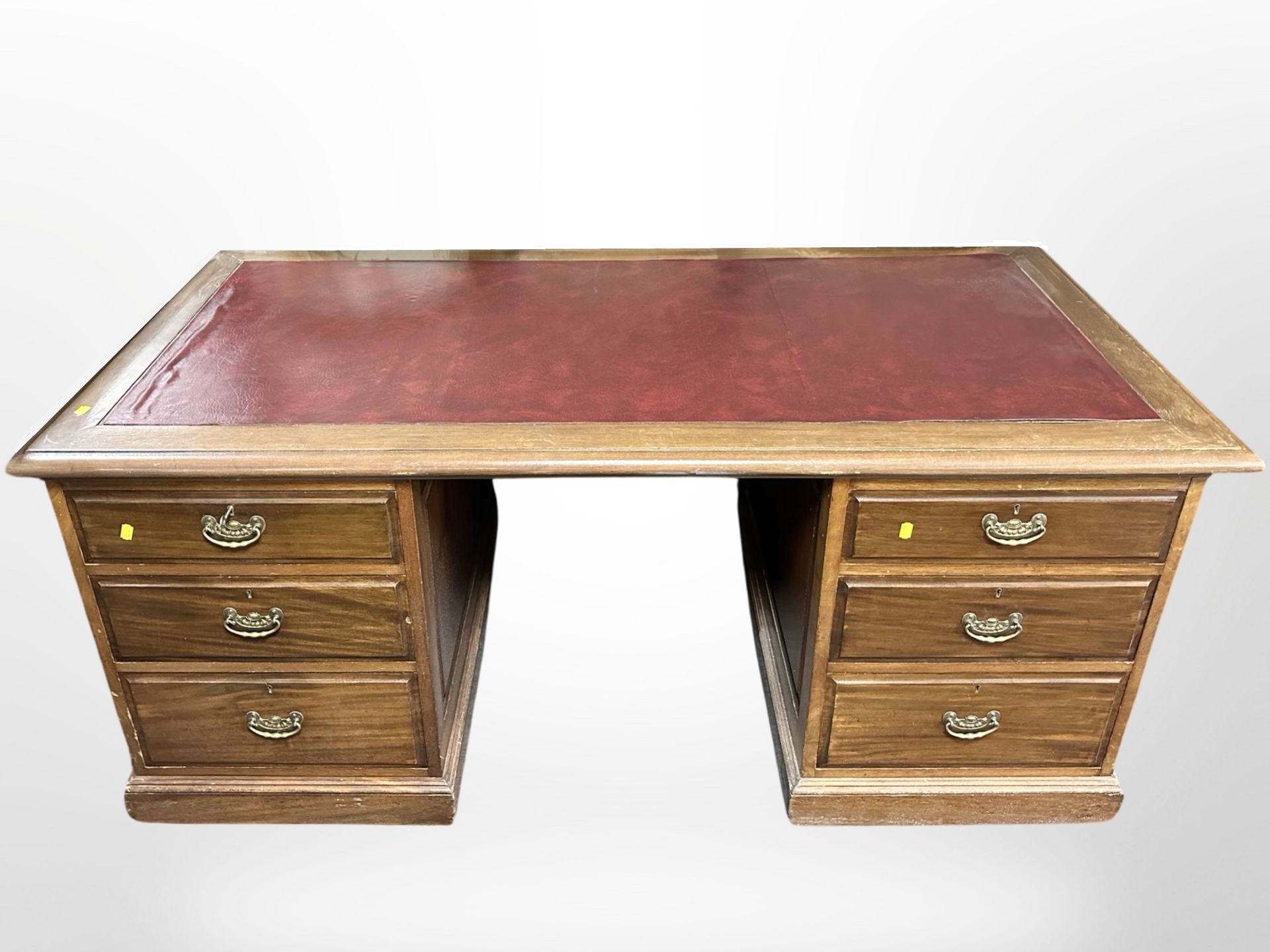 An early 20th century mahogany twin-pedestal writing desk with red leather inset panel,