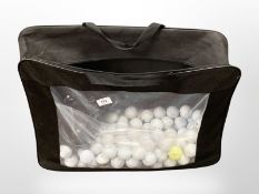 A large collection of golf balls together with a gel bike saddle.