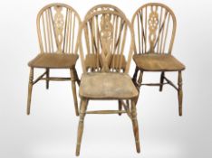 A set of four oak wheel back dining chairs