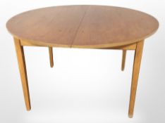 A Danish teak extending circular dining table, with leaf,
