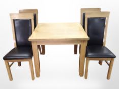 A contemporary oak dining table and four high-backed chairs