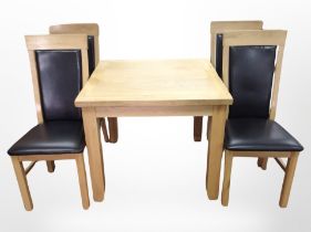 A contemporary oak dining table and four high-backed chairs
