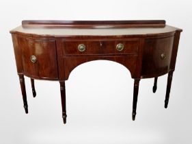 A 19th century mahogany bow-front buffet sideboard in the George III style,