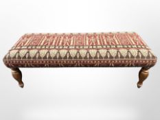 A reproduction rectangular footstool in Egyptian style fabric,