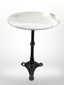 A cast iron tripod table with marble top,