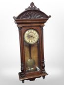 A Victorian walnut Vienna wall clock with enameled dial, height 105cm.