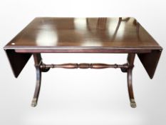 A reproduction mahogany drop leaf coffee table on brass capped feet,