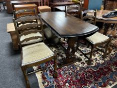 An Ercol stained elm drop leaf dining table and set of four ladder backed chairs