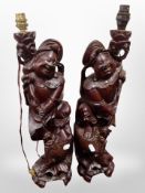 A pair of Chinese carved hardwood figural table lamps, height 54cm.