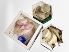 Three hat boxes containing assorted lady's dress hats.