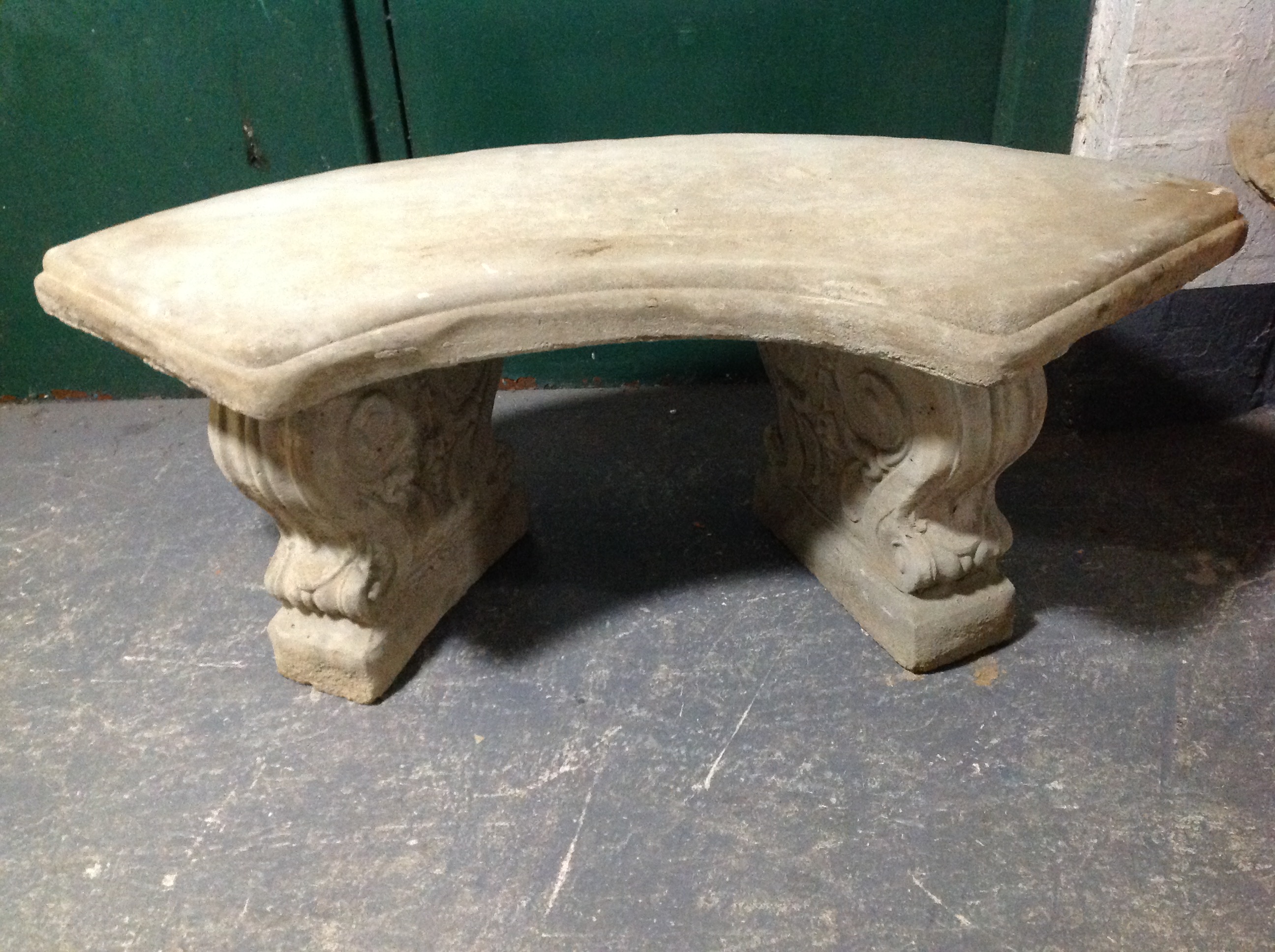 A concrete garden bench on classical-style pedestals, width 102cm.