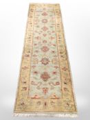 A Persian style runner on green ground 250 cm x 71 cm