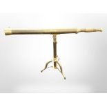 A reproduction brass telescope, 84cm long, on tripod stand.