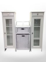 A pair of contemporary white side cabinets and a wicker table