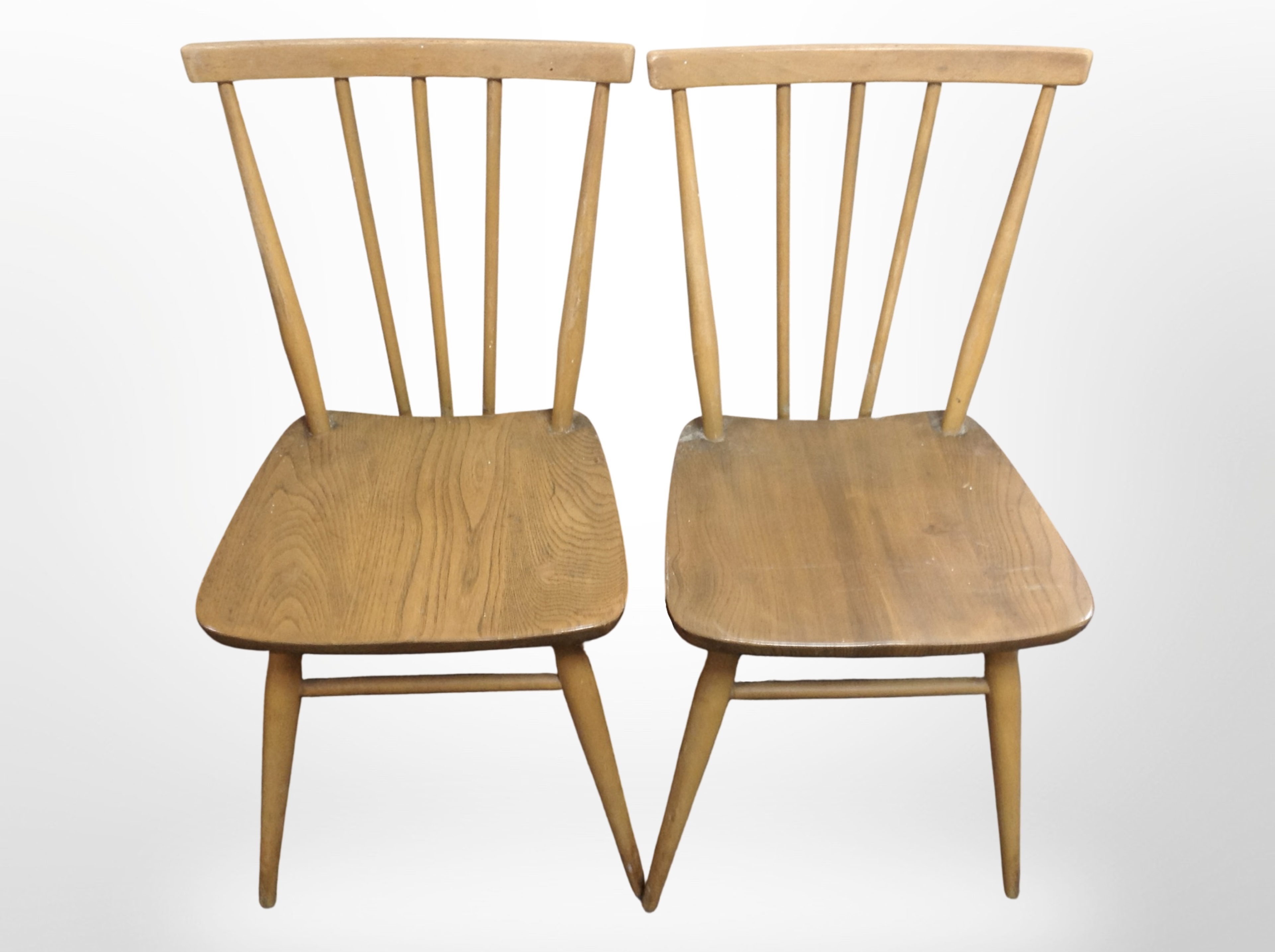 A pair of Ercol elm and beech spindle-back dining chairs.