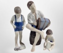 A Bing and Grøndahl figure of a boy playing an accordion, plus two others, tallest 23cm.