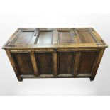 A reproduction panelled oak and cast-iron-mounted blanket chest on castors,