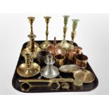 A group of brass candlesticks and chamber sticks, pewter example, brass weights, copper funnel, etc.