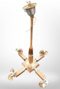A mid-20th century walnut-veneered four-sconce pendant light fitting, height 70cm.