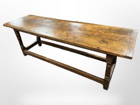 An 18th-century oak plank-top refectory dining table, 223cm long x 65cm wide x 77cm high.
