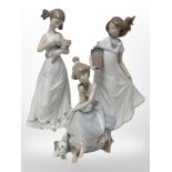 A Lladró figure of a girl and a dog, No. 5466, and two Nao figures of girls.
